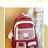 A maroon and white backpack featuring a checkered pattern, a cute cat design, and a laptop compartment.