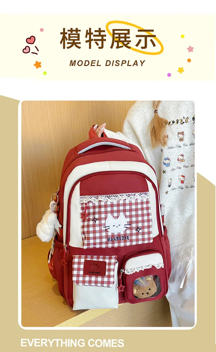 A maroon and white backpack featuring a checkered pattern, a cute cat design, and a laptop compartment.