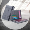 A gray PU leather passport holder with various slots and a passport wallet is displayed on a light surface.