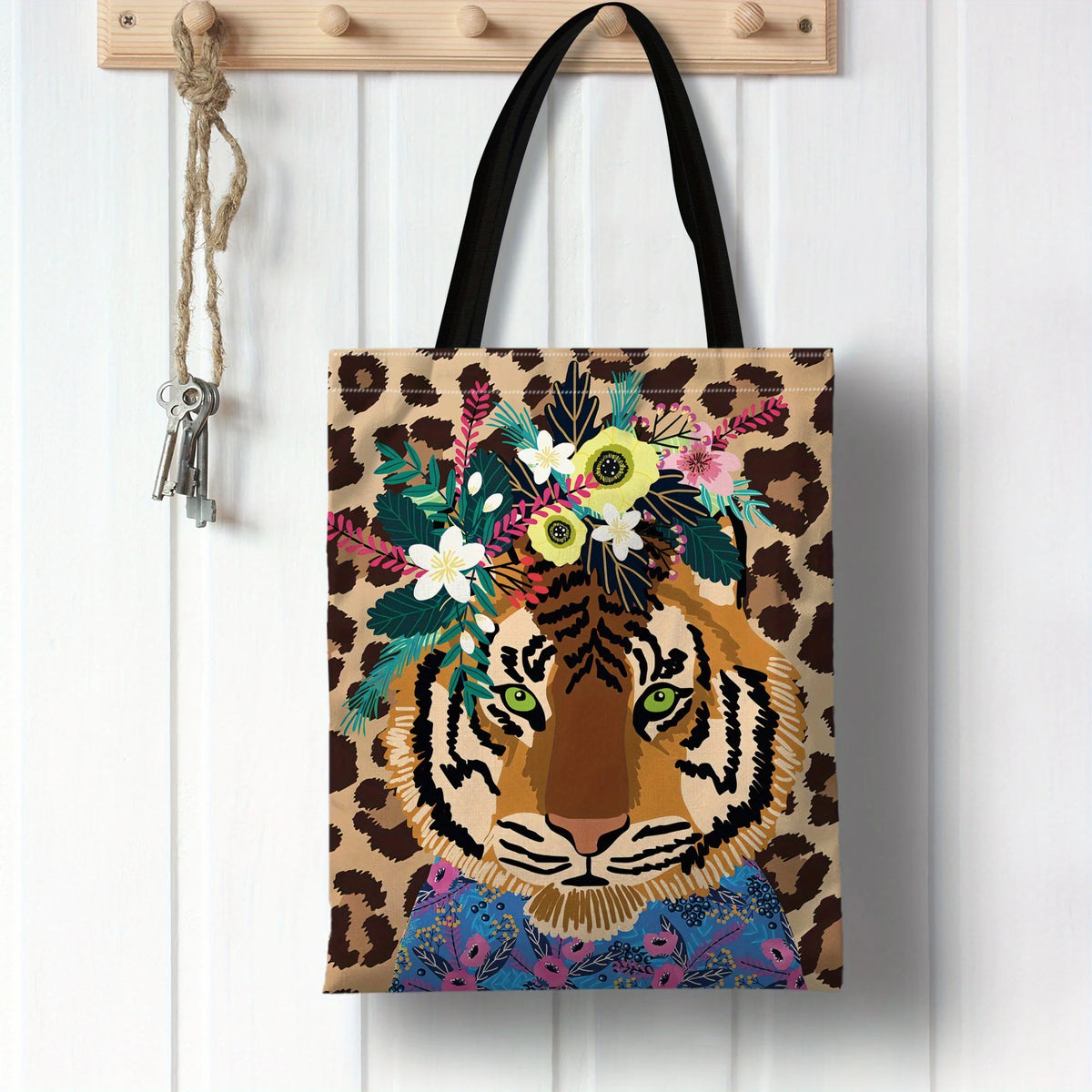A canvas tote bag featuring an illustration of a tiger's face surrounded by a colorful floral wreath on a leopard print backg