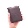 A hand holds a dark brown genuine leather men's business wallet with a zipper.
