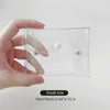 A hand holds a clear, transparent portable organizer pouch for cosmetics and tools.