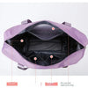 Pochette de voyage multi-usage violette extensible, ouverte, montrant ses fonctionnalités d'organisation interne.