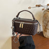 A dark brown woven crossbody bag with a silver chain strap is held against a light background.