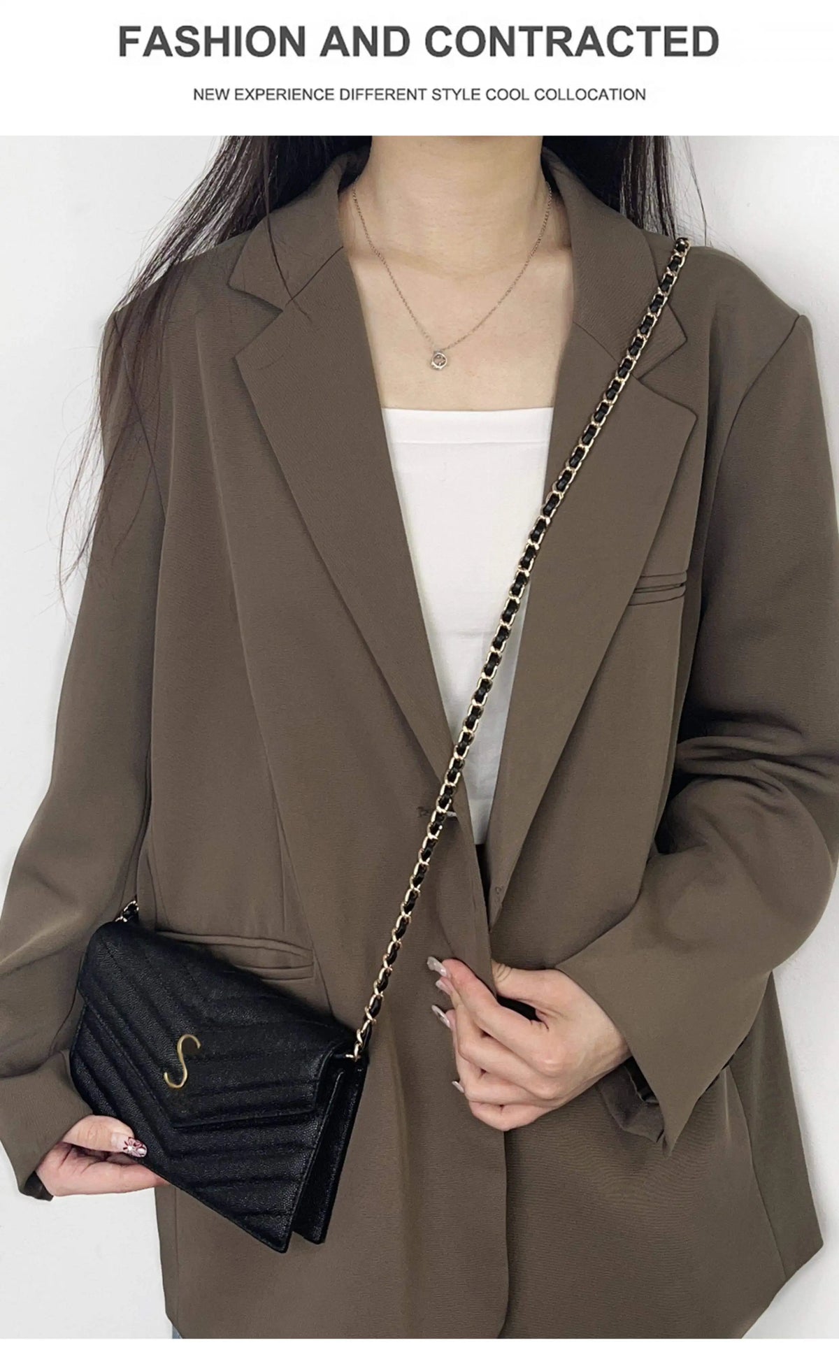 A woman models a brown blazer and white top, featuring a black bag with a gold chain strap.