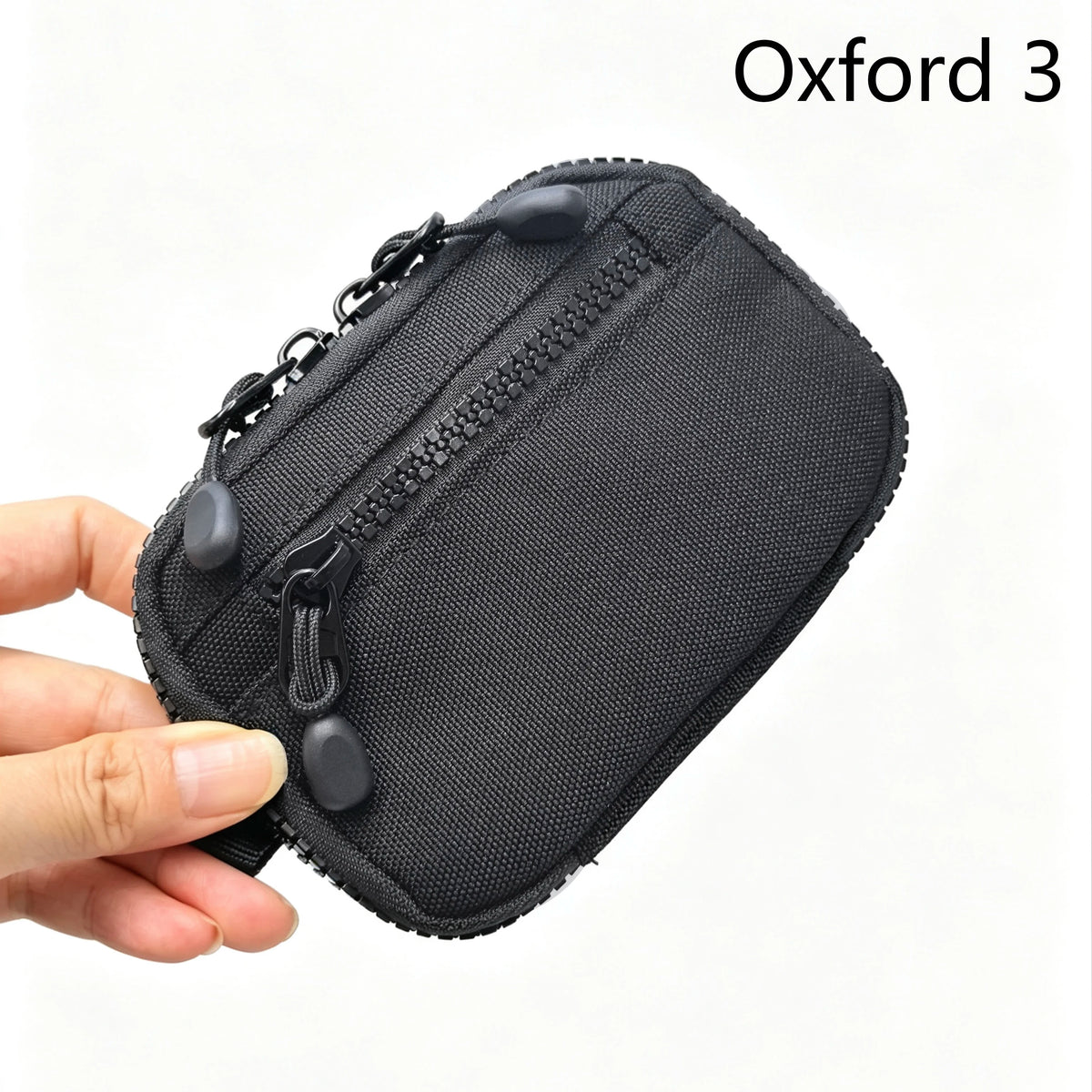 Une pochette utilitaire noire Oxford de marque 3 pour clés et essentiels tenue dans une main.