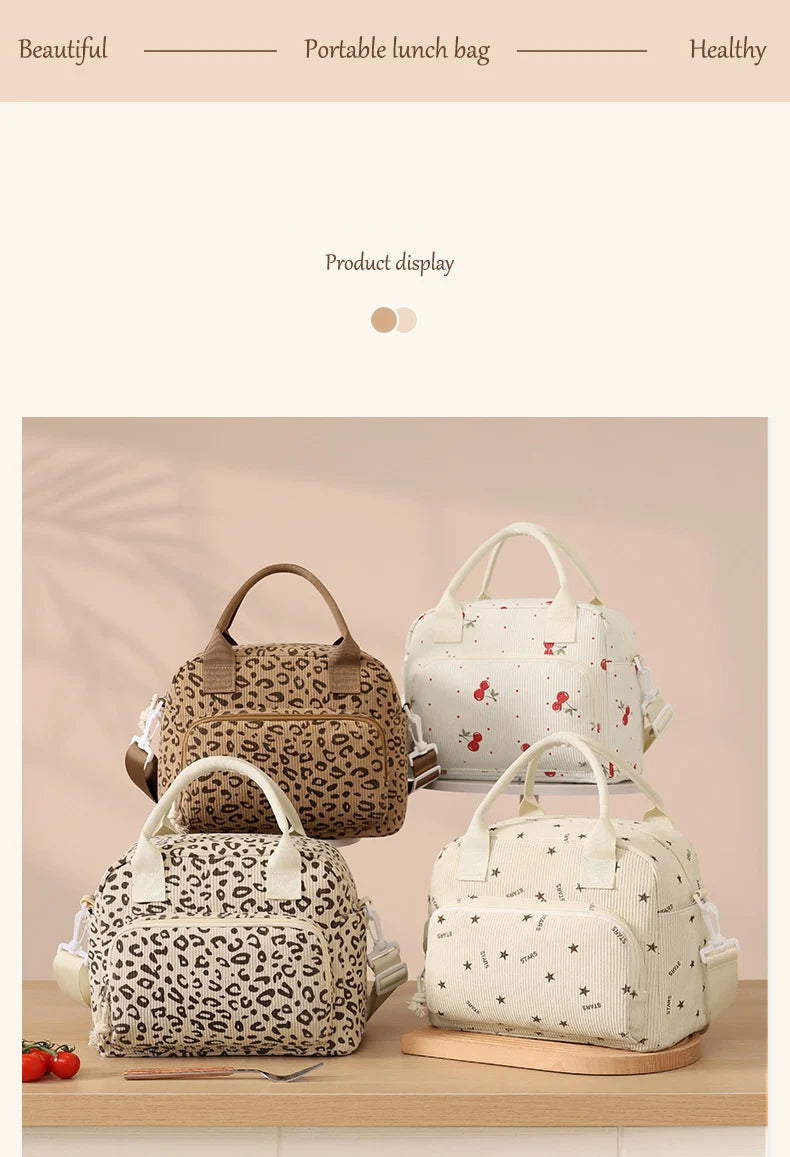 Two beige and brown floral corduroy insulated lunch bags displayed on a wooden surface.