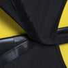 Black stretch fabric luggage protector cover with black strap on a yellow background