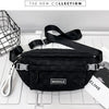 Black plaid crossbody chest bag with adjustable strap displayed on a white surface.