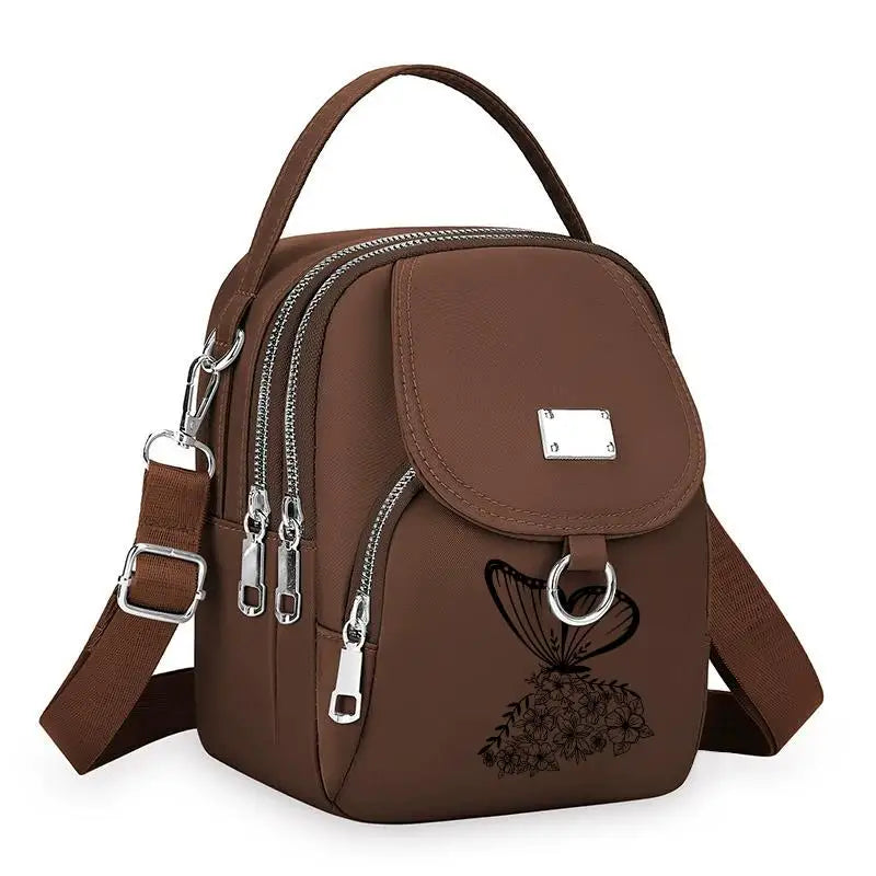 Sac bandoulière floral marron et durable avec fermeture éclair et sangle en cuir.