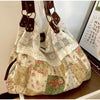 A bohemian floral patchwork shoulder bag featuring white lace and patterned fabric in pinks, greens, and creams.