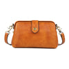 A tan genuine leather crossbody bag with a brass buckle closure.
