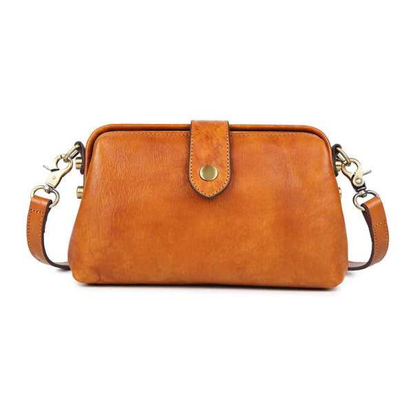 A tan genuine leather crossbody bag with a brass buckle closure.