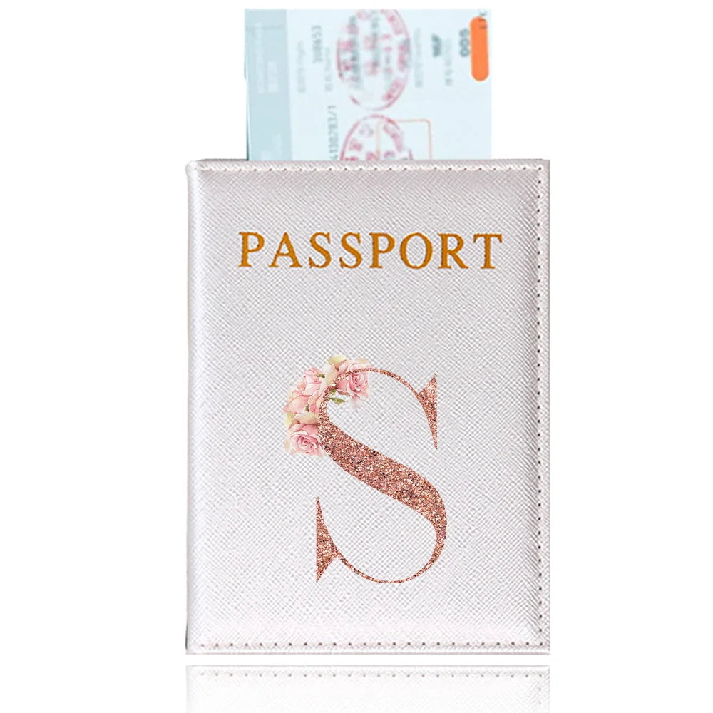 A light pink leather passport holder featuring a gold embossed letter S design.