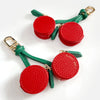 Red cherry fruit shape coin purse keychain with green leather strap and gold clasp