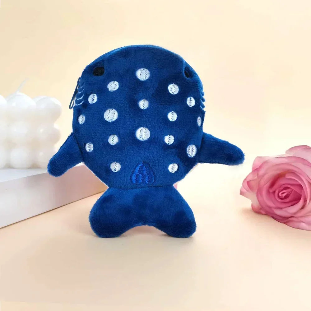 A dark blue shark mini plush toy with white polka dots resting on a light surface.