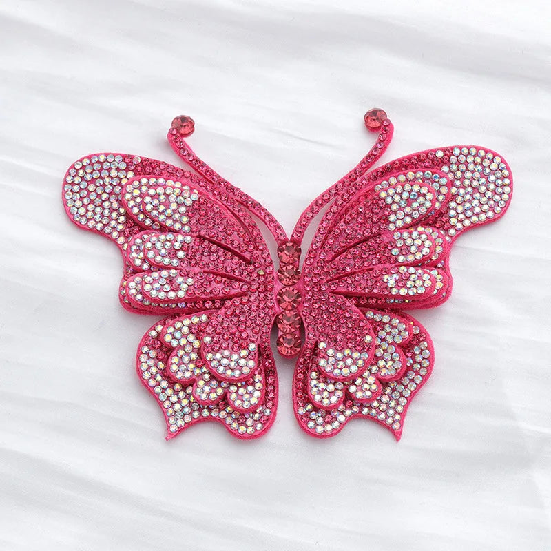 A pink rhinestone butterfly applique sticker with detailed wings and antennae.