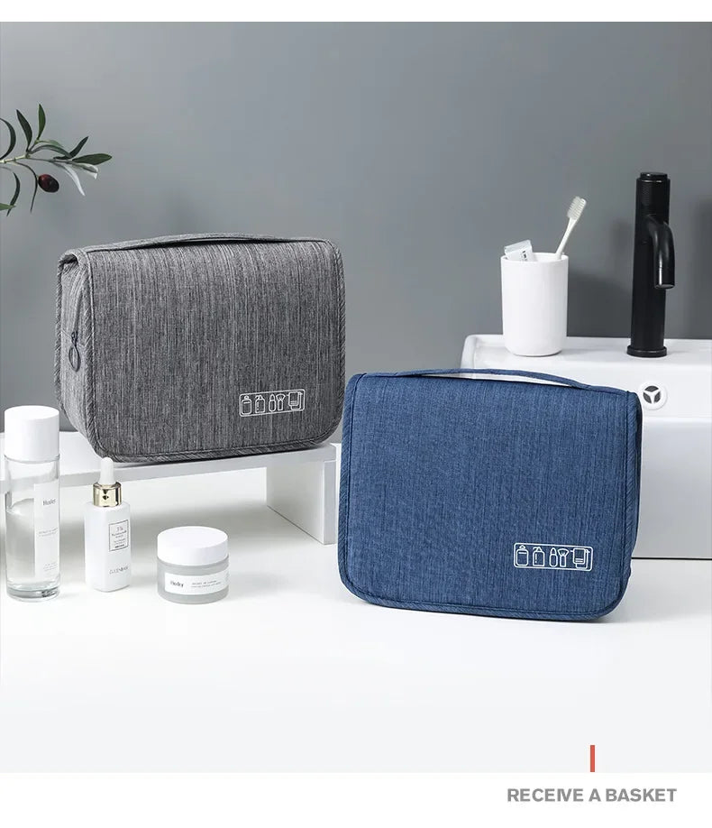 Un sac organisateur en tissu bleu foncé portable est exposé sur une surface blanche à côté de produits de toilette et d'une b