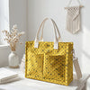 Sac en corduroy jaune à pois roses, exposé sur une surface blanche avec des fleurs séchées.