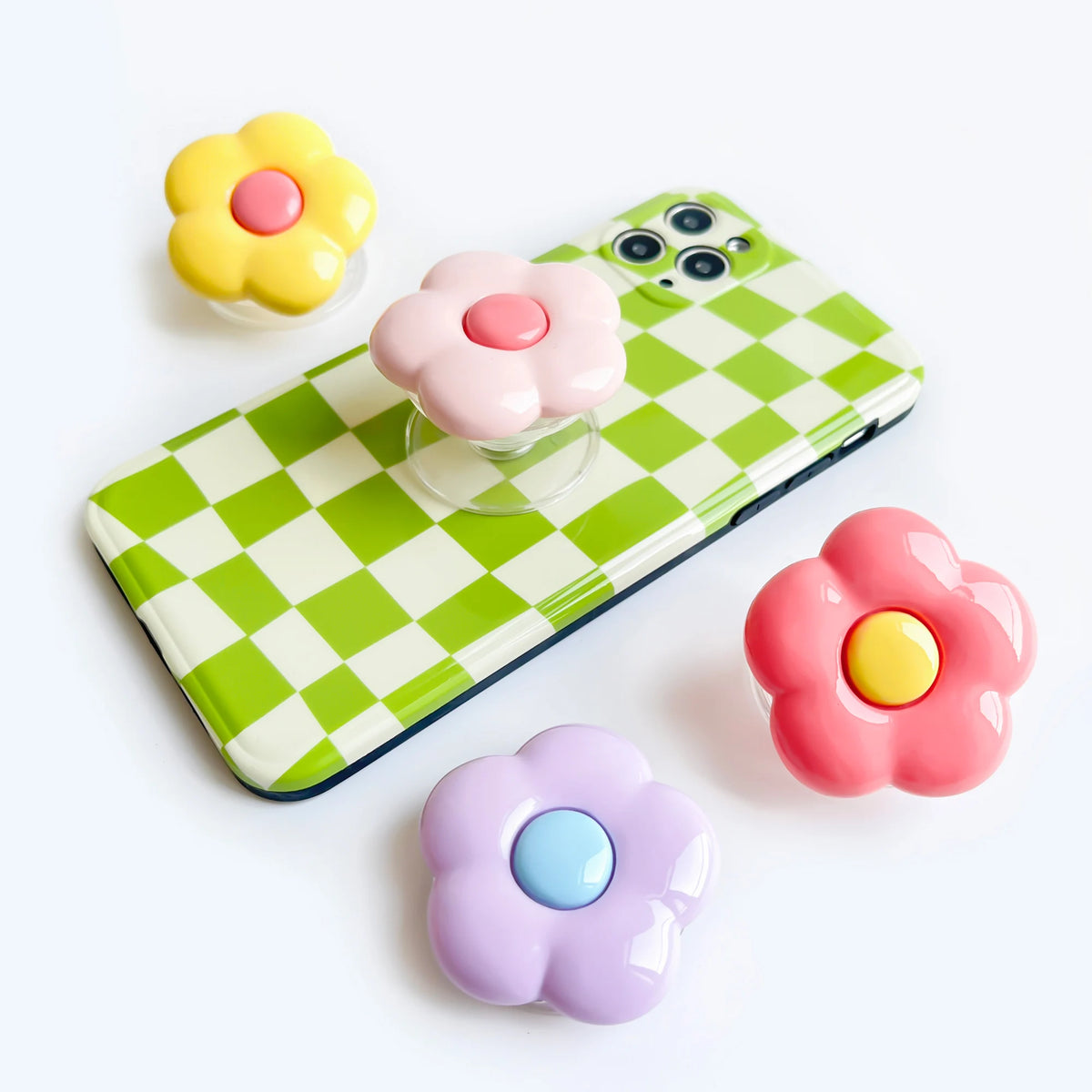 A colorful foldable phone grip ring stand featuring pink, yellow, and purple flower shapes.