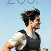 A man wearing a black running chest pack is jogging outdoors against a blue sky and sea background.