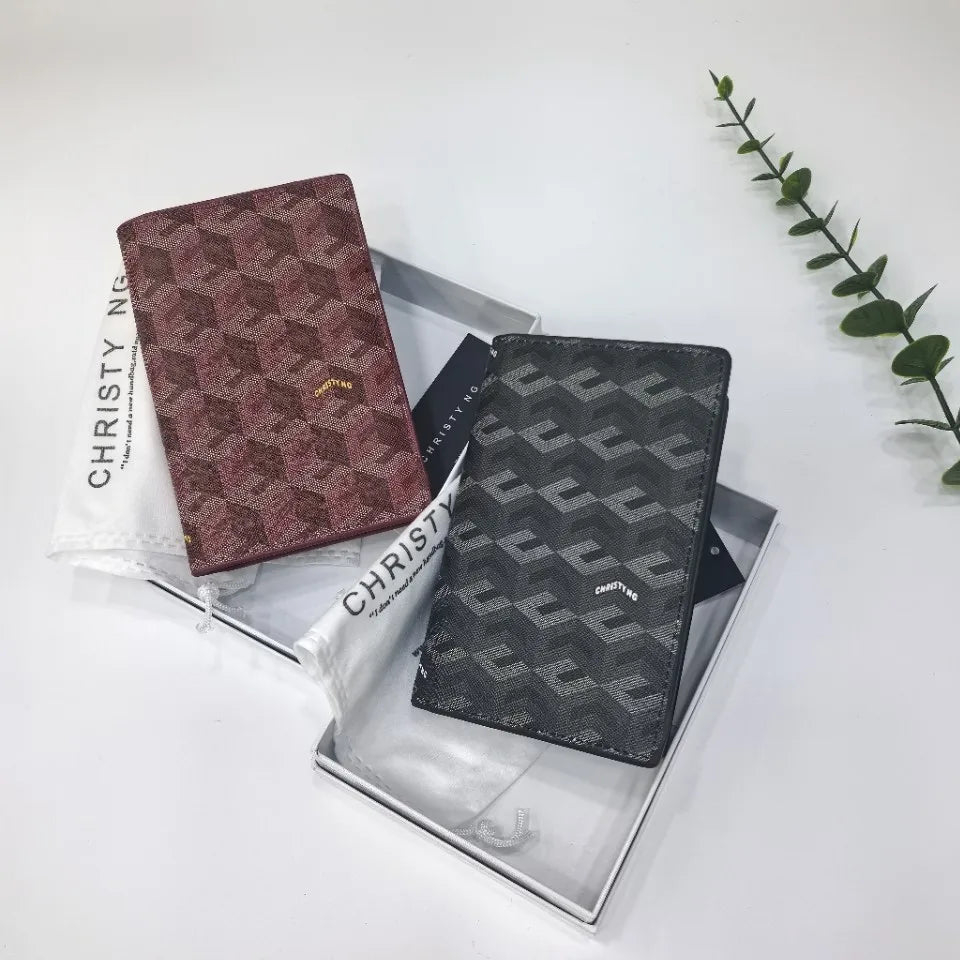 Two passport wallets featuring geometric prints in maroon and gray are displayed in a silver box.