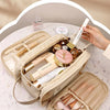 A beige makeup bag organizer showing various cosmetic products and tools inside.