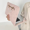 A pink PU laptop sleeve with a gold chain charm is shown next to an open silver laptop.