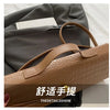 A tan crocodile-embossed PU leather clutch bag is shown resting on a gray blazer.