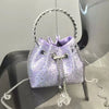 A purple crystal-embellished evening clutch with a silver chain strap displayed on a black surface.