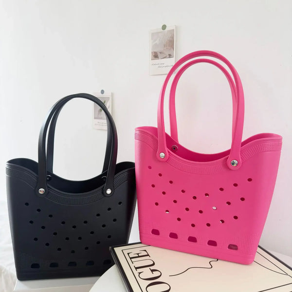 Una bolsa tote impermeable de EVA rosa brillante con diseño perforado, mostrada sobre una superficie blanca.