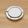 A silver folding alloy handbag hanger hook resting on a light wooden surface.