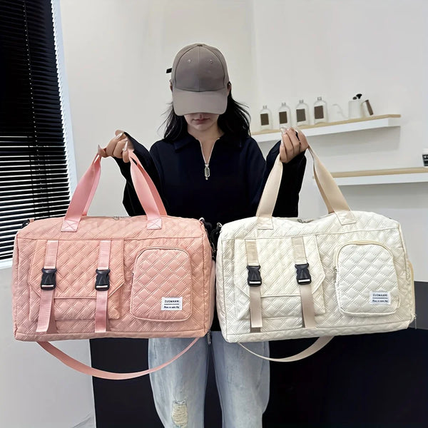 A woman holds a pink nylon travel duffle bag with an argyle pattern in front of her.