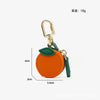 Orange fruit-shaped PU leather coin purse keychain with a gold-colored clasp