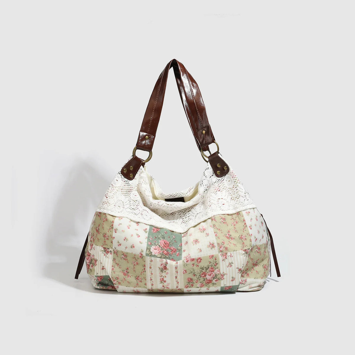 A beige and pink floral patchwork shoulder bag with brown leather straps.