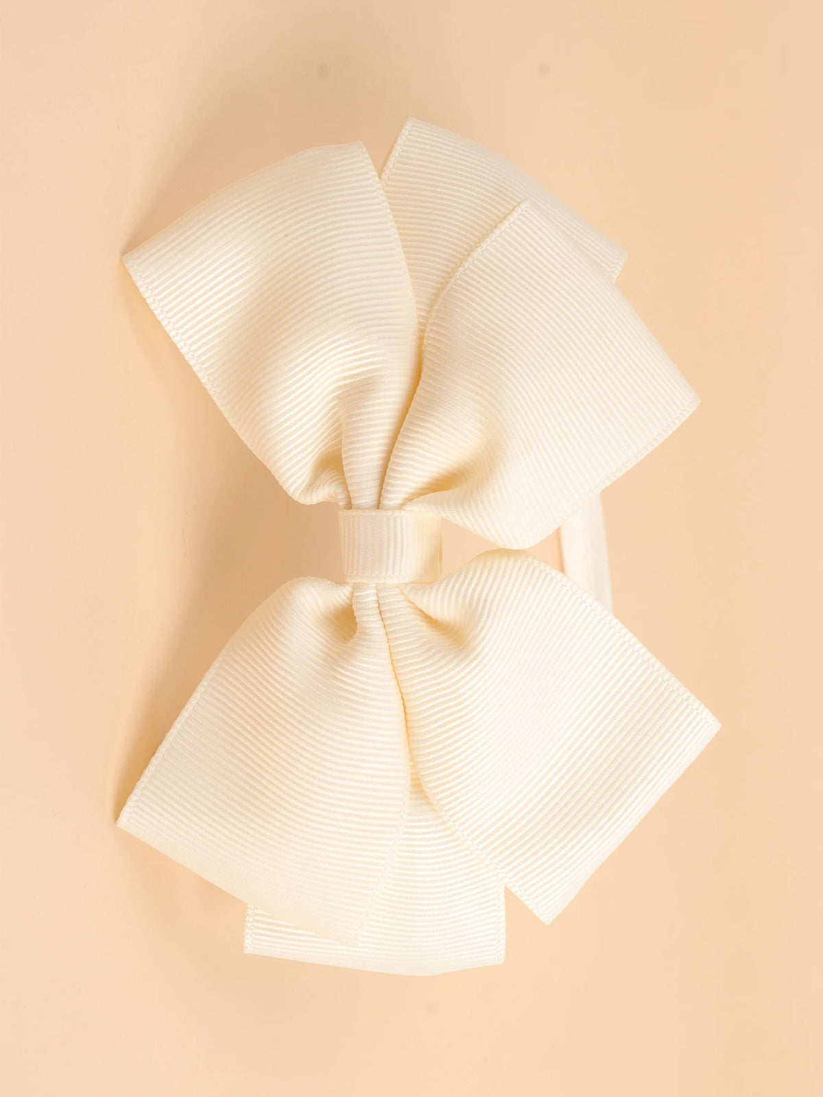 A set of twenty cream-colored ribbed fabric bow hairbands laid flat on a light beige background.