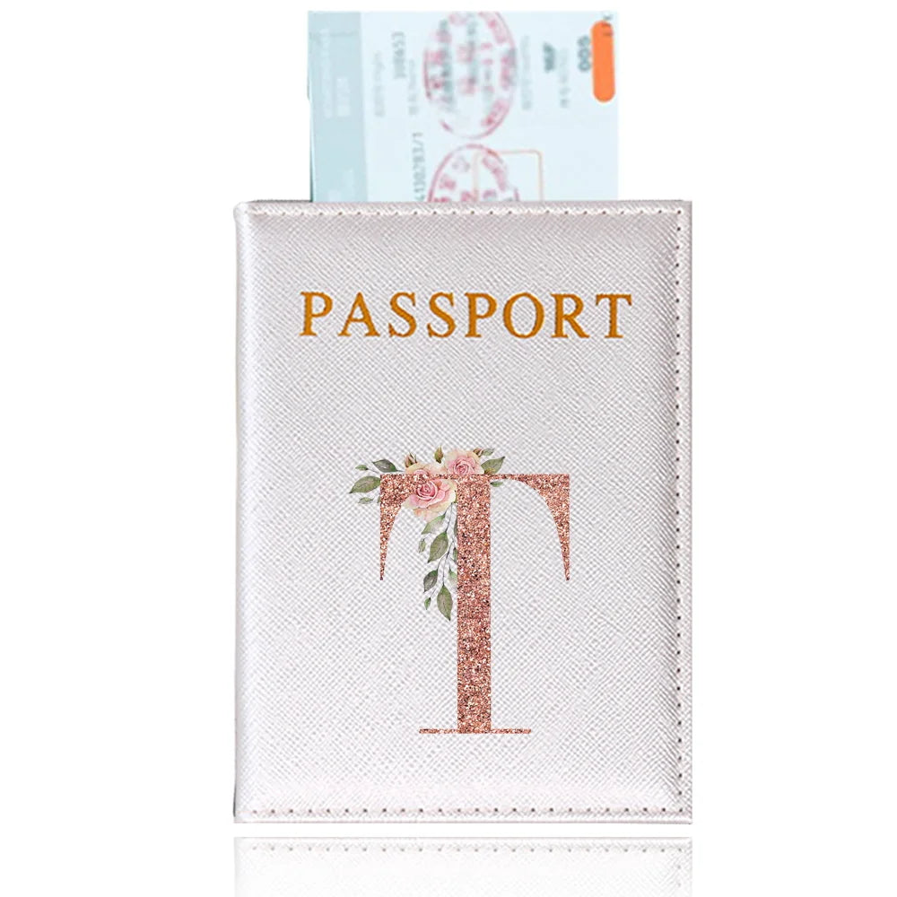 A pink leather passport holder featuring a gold serif letter T design and an ID card.