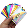 Una mano sostiene una pila de fundas para tarjetas RFID coloridas, mostrando varios tonos de azul, verde, amarillo y rosa.