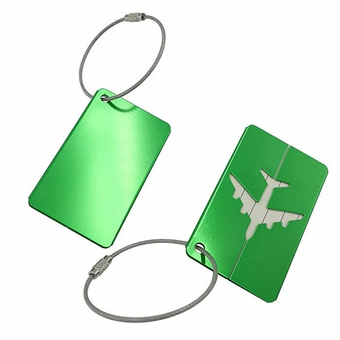 A green aluminum luggage tag with a silver cord attached, featuring a white airplane silhouette.