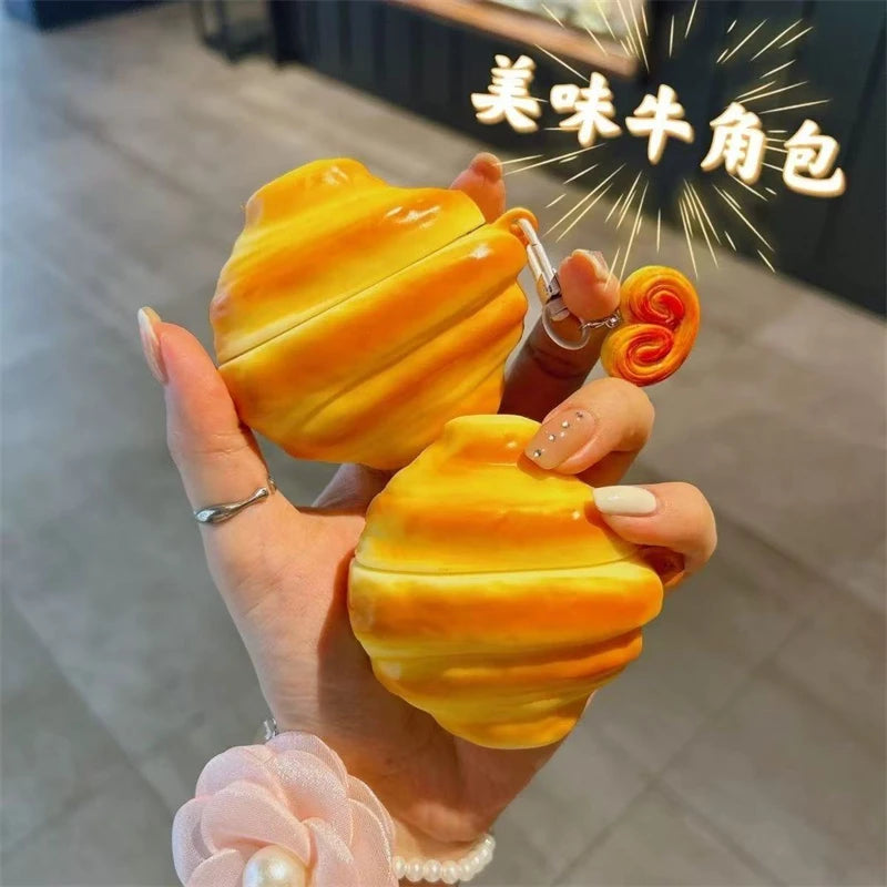 A hand holds a bright yellow silicone protective case for wireless earbuds against a dark background.