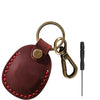 A brown MagSafe card wallet with a built-in pocket for an AirTag, attached to a black key.