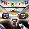 Dos personas en un coche llevan protectores para la cabeza dobles negros con decoración de Halloween.