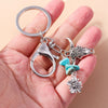 Silver gothic steampunk heart keychain with a sun eye pendant held in a hand