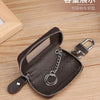 A dark brown leather car key case with a transparent window and silver chain attached, shown on a wooden surface.