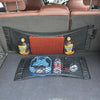 A black mesh organizer net bag is shown inside a car trunk, holding various items like bottles and balls.