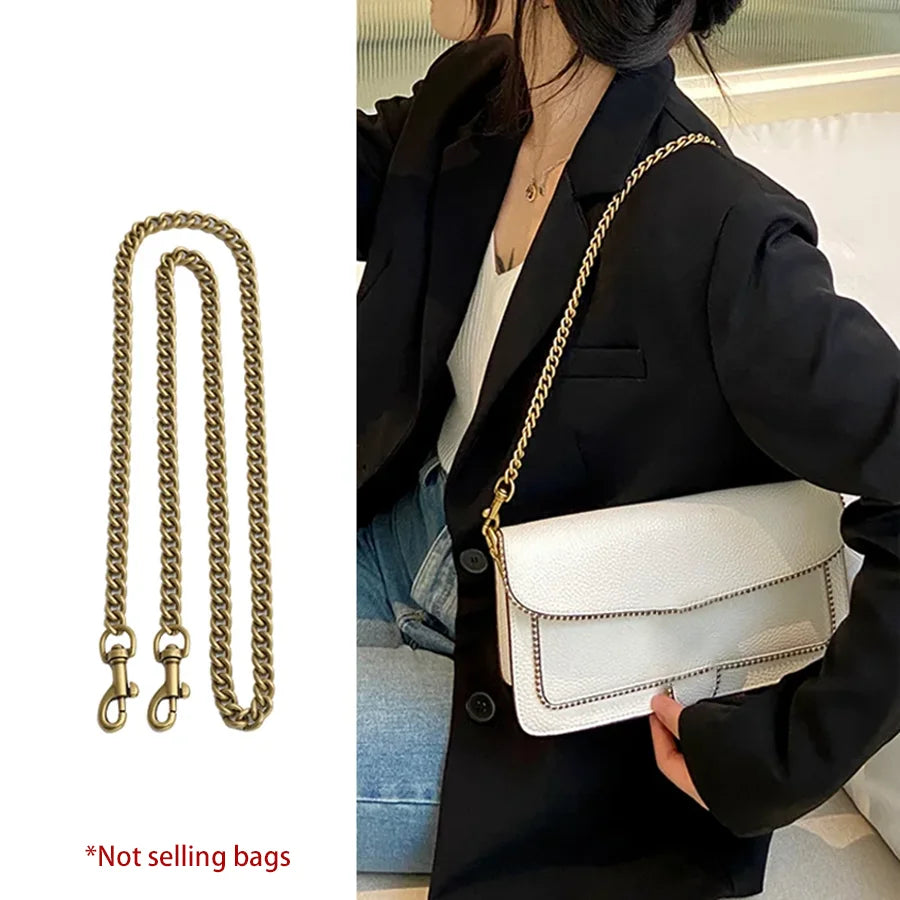 A woman holds a white quilted handbag with a gold metal chain strap under a black coat.