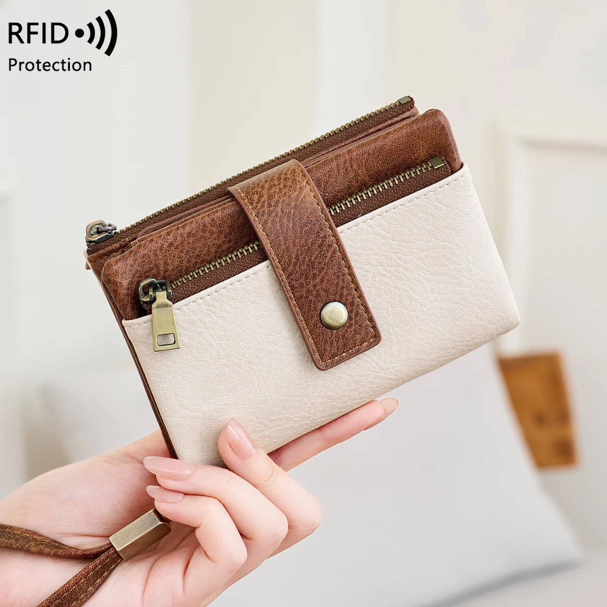 A brown leather wallet with a beige lining and gold zipper is being held by a hand.