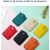 A collection of multiple colored genuine leather slim card holders displayed on a light pink and mint green background.