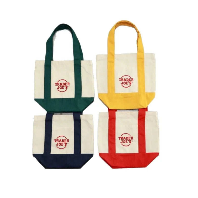 Three canvas bags in white, green, yellow, and navy blue with red accents.