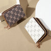 A pair of vintage-style zippered card holder wallets in brown and white patterns resting on a beige surface.